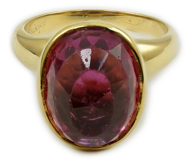 A modern 18k gold and single stone fancy oval cut deep pink tourmaline set dress ring, signed Asprey?